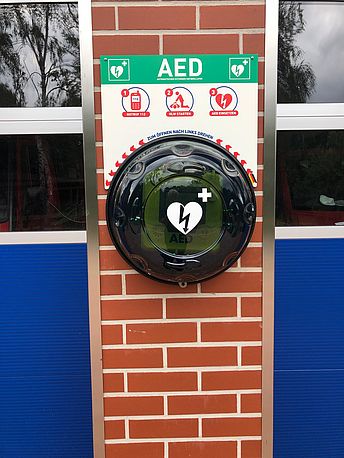 AED befindet sich zwischen den Fahrzeugtoren